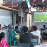 “Babinsa dan Warga Bersatu Dalam Suasana Kebersamaan Nobar Piala Dunia 2026”.